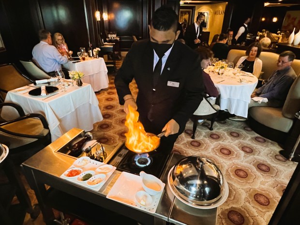 Cognac-flambéed lobster tail is prepared tableside at Murano, a specialty restaurant on Solstice. (Photo by David Dickstein)