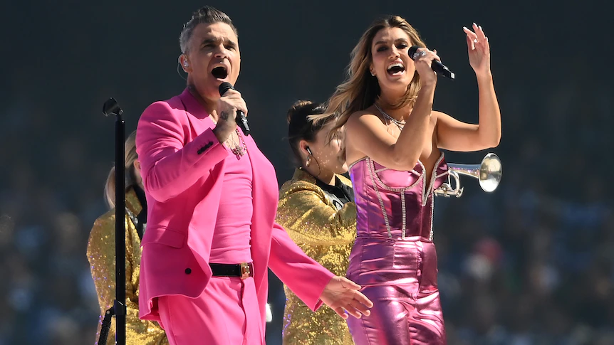 Robbie Williams rocks AFL grand ultimate pre-match leisure with Delta Goodrem and Shane Warne tribute — however no Kylie Minogue