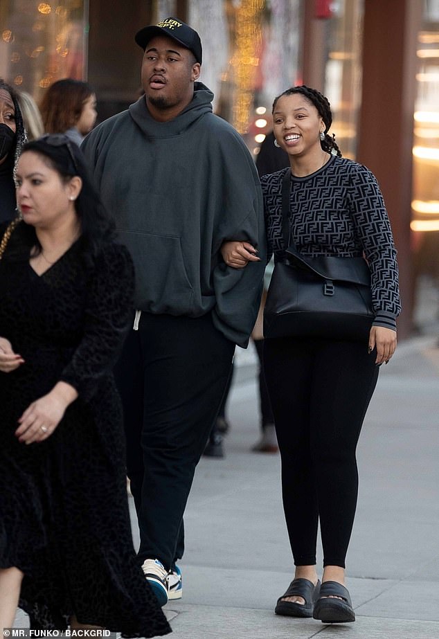 Chloe Bailey locks arms with a person buddy as she does some last-minute Christmas procuring