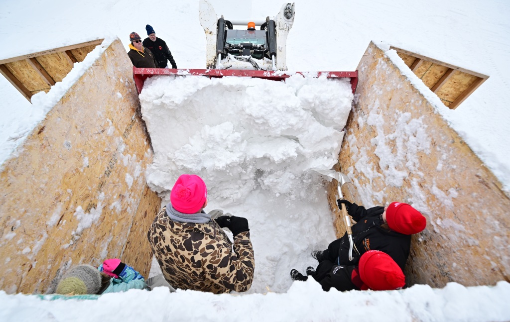 Stomp! Volunteers pack snow piles into cubes for Winter Carnival carving contests – Twin Cities